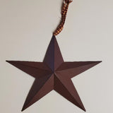 Primitive 12-inch burgundy metal barn star with a homespun plaid fabric hanger on a plain background.