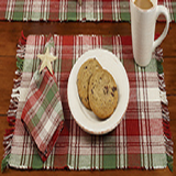 A Christmas themed placemat with red, green, and cream colors
