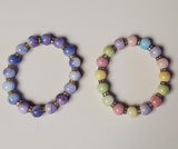 Two beaded bracelets on a light gray background
