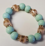 Beaded bracelet with turquoise beads and gold accents on a white background